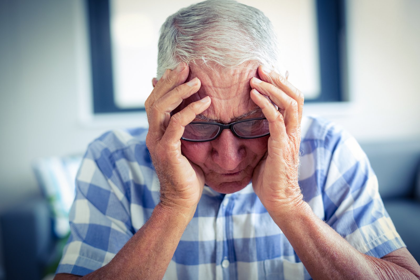 Senior man suffering from headache at home