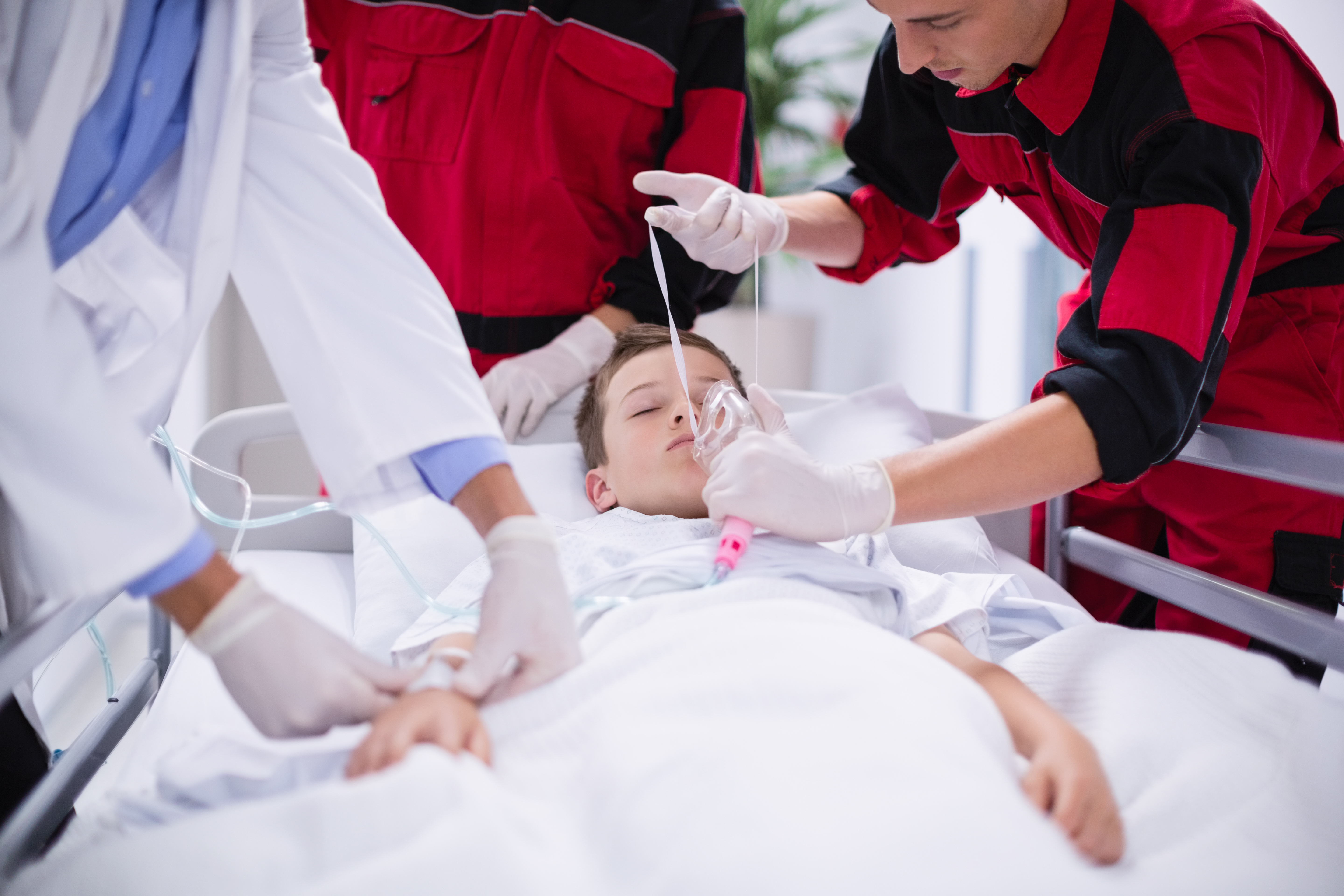 Doctors adjusting oxygen mask while rushing the patient in emergency room at hospital