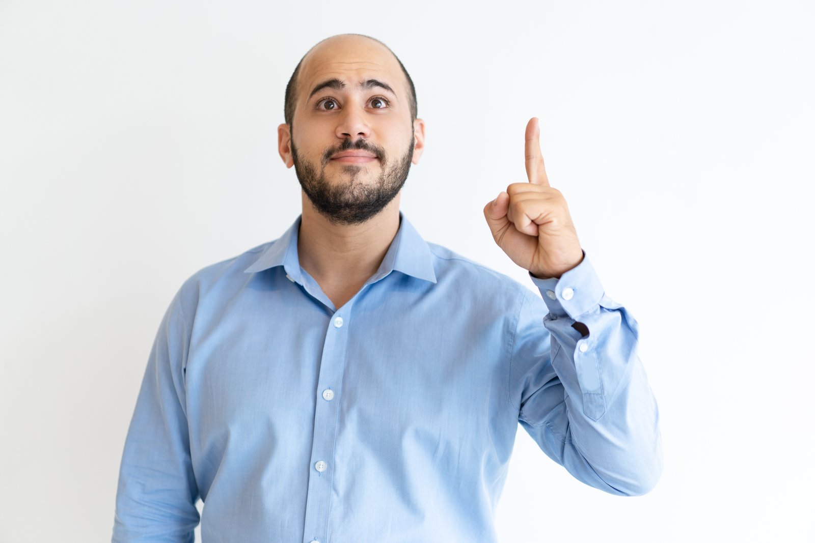 Excited man pointing forefinger upwards. Attractive guy and recommending something. Promotion concept. Isolated front view on white background.