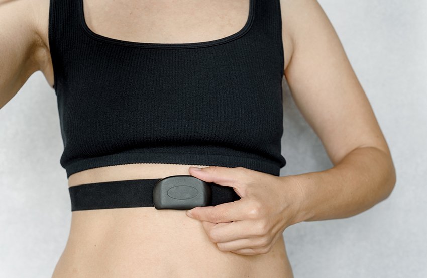 Fitness woman with heart rate monitor, woman wearing heart rate chest strap used for jogging, healthy lifestyle